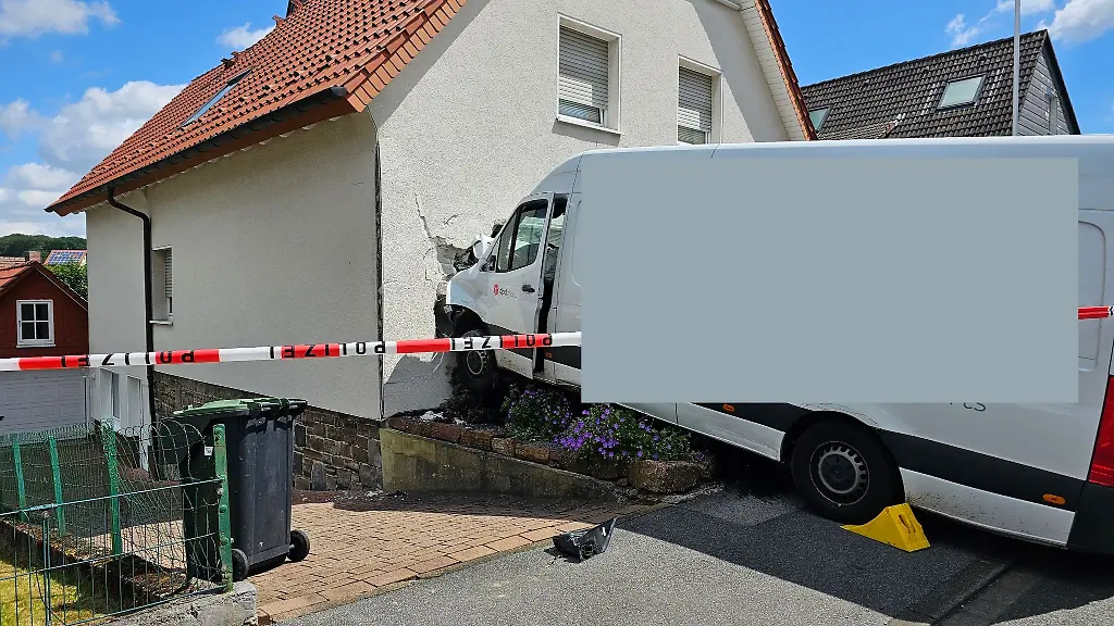 Ein-die-Strasse-hinabrollender-Pakettransporter-wurde-durch-eine-Hauswand-gestoppt