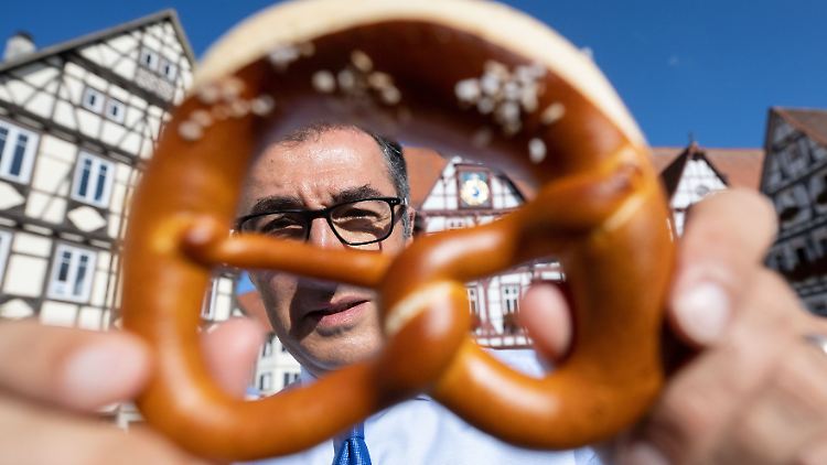 Lokalpatriot und Bundesminister für Ernährung und Landwirtschaft: Cem Özdemir auf dem Marktplatz seines Geburtsorts Bad Urach mit einer Brezel. Sie soll immaterielles Kulturerbe der UNESCO werden.