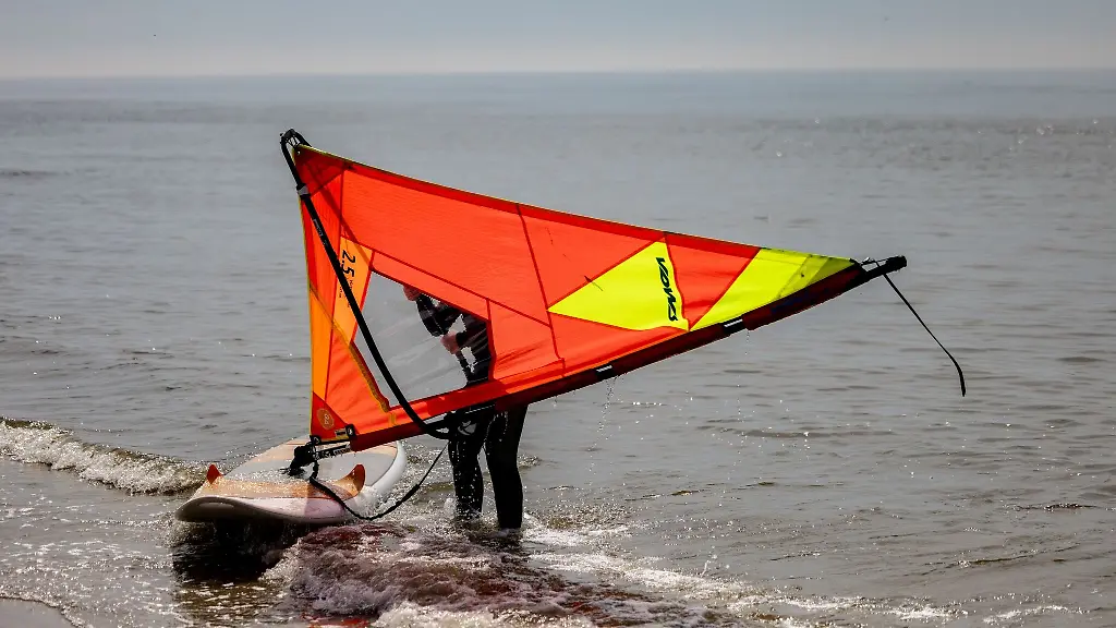 Ein-Windsurfer-uebt-am-Strand-von-St-Peter-Ording-die-Balance-auf-dem-Brett-zu-halten