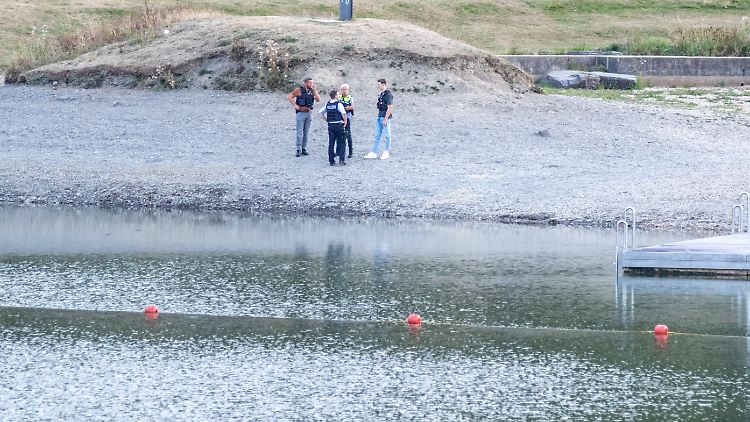 Polizisten stehen nach dem tödlichen Badeunfall am Wasser.