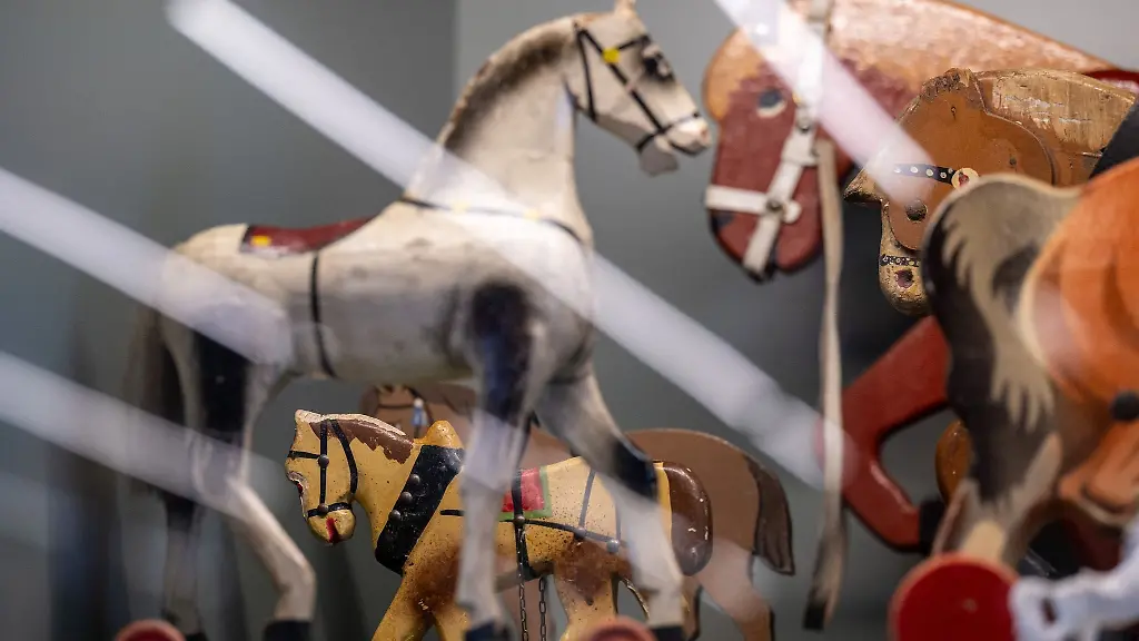 Historisches-Kinderspielzeug-steht-in-einem-Archivschrank-im-Schaudepot-des-Kinderwagenmuseums