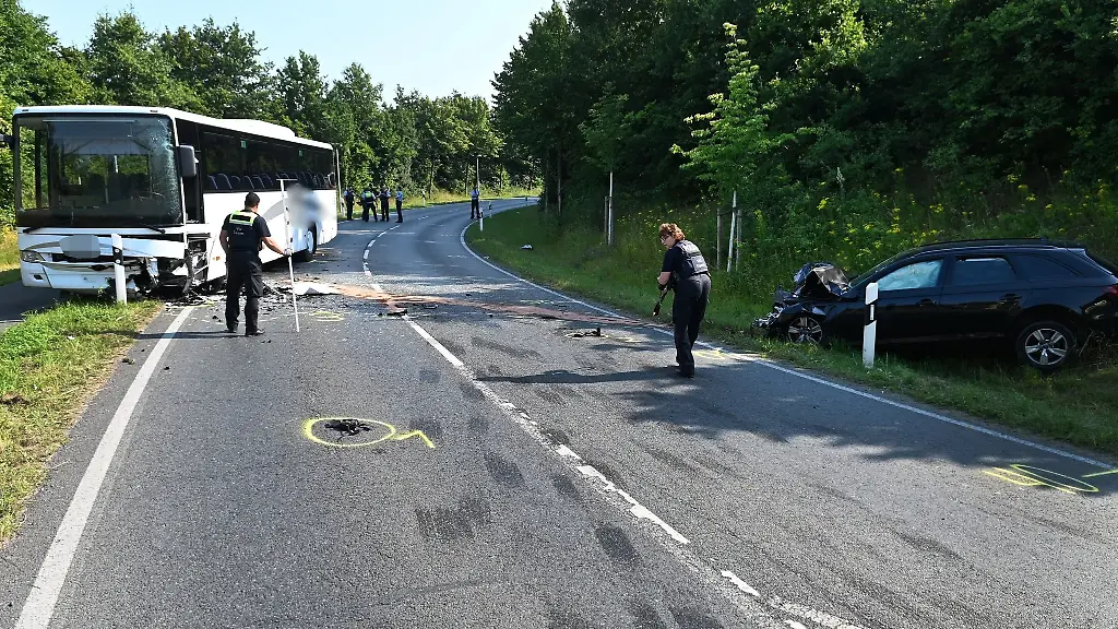 Ein-beschaedigter-Schulbus-und-ein-kaputtes-Auto-stehen-an-einer-Unfallstelle-in-Duelmen
