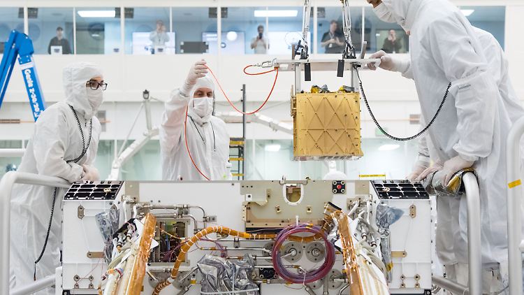 Mitglieder des NASA-Projekts Mars 2020 installieren im März 2019 das Mars Oxygen In-Situ Resource Utilization Experiment (MOXIE) in das Fahrgestell des nächsten Mars-Rovers. MOXIE soll Sauerstoff auf dem Mars gewinnen.