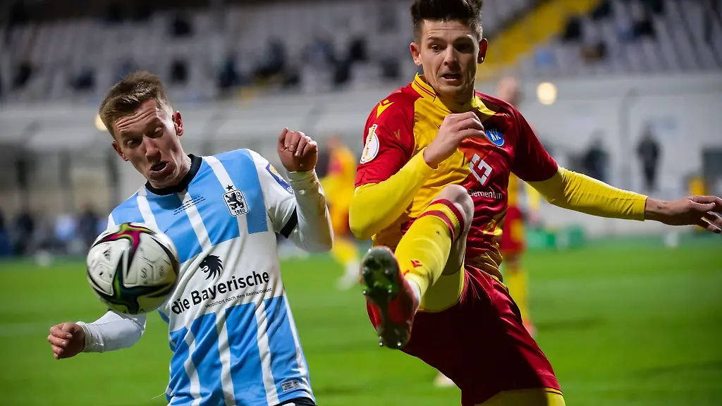 Fabian-Greilinger-l-von-Muenchen-und-Marvin-Wanitzek-von-Karlsruhe-kaempfen-um-den-Ball