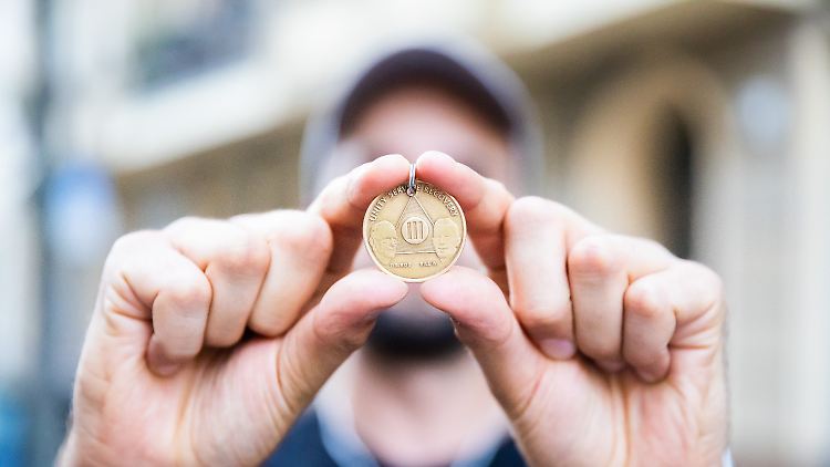 Für Paul ist die Plakette der Anonymen Alkoholiker eine Erinnerung an seine Sucht.