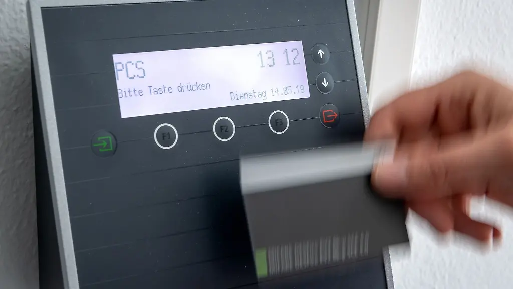 Ein-Mitarbeiter-erfasst-seine-Arbeitszeit-digital-an-einem-Terminal