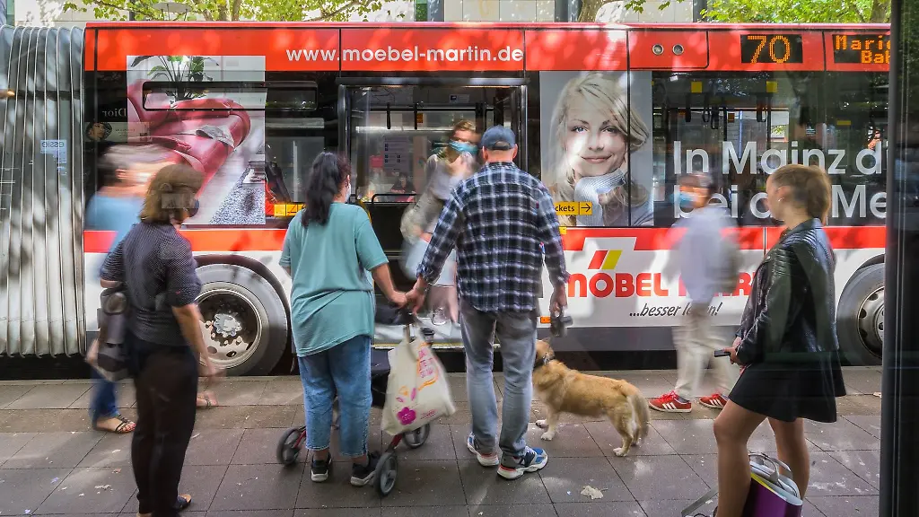 Menschen-stehen-in-der-Innenstadt-vor-einem-Stadtbus-an