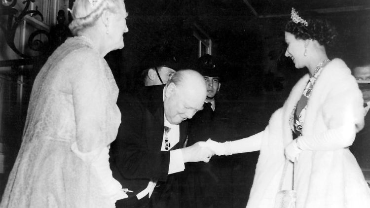 Churchill wartet mit einer tiefen Verbeugung und einem Lächeln bei der Queen auf.