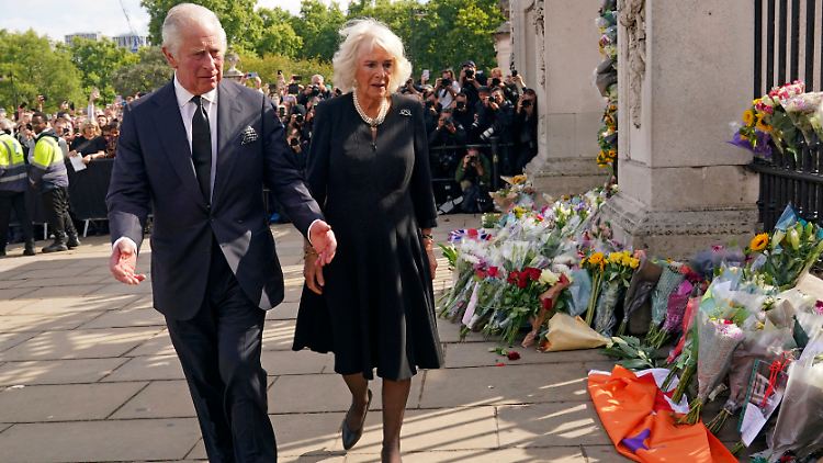 Während Charles und Camilla das Blumenmeer am Buckingham-Palast besichtigen, steht ihnen die Trauer ins Gesicht geschrieben.