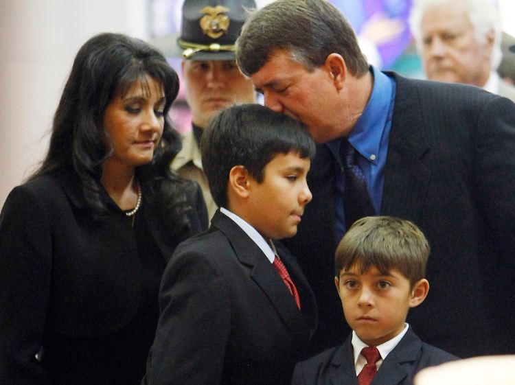 Christinas Familie am Sarg des Mädchens.
