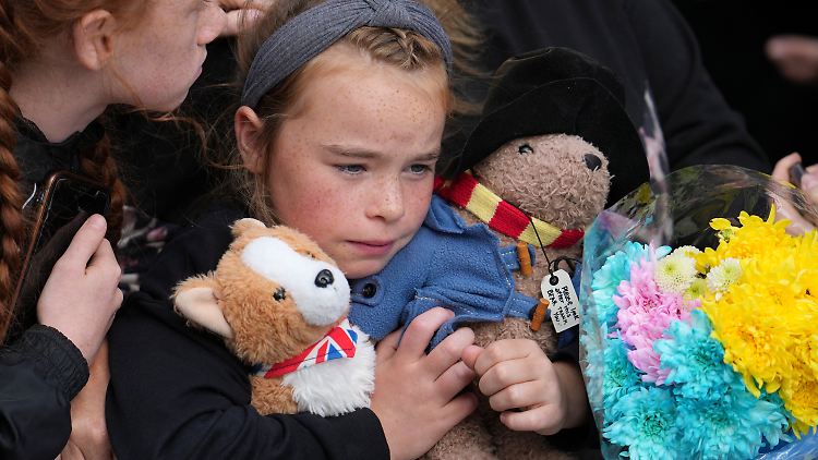 Mit Corgi und Paddington-Bär nimmt ein Mädchen Abschied von der Queen.   