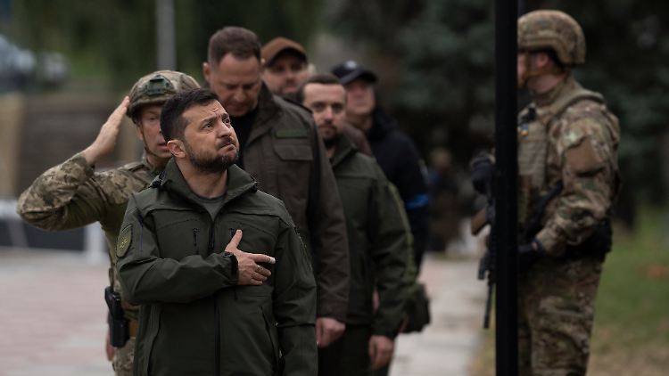 Wolodymyr Selenskyj sieht dabei zu, wie die ukrainische Nationalflagge in der kürzlich zurückeroberten Stadt Isjum wieder gehisst wird.