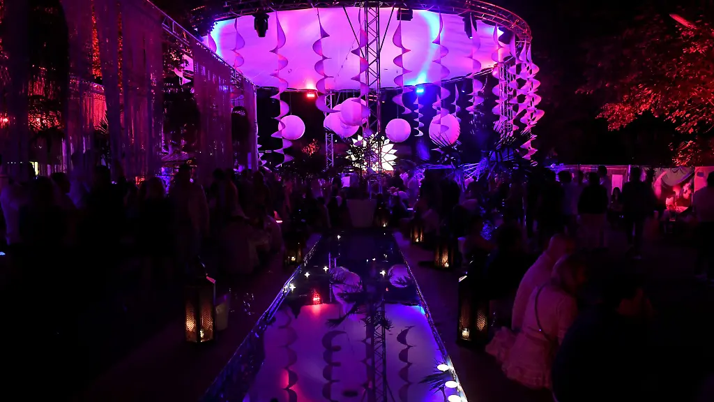 Grosse-Luftschlangen-und-ein-rundes-Dach-unter-dem-die-Gaeste-feiern-spiegelt-sich-in-einem-Wasserbecken-beim-Sommerfest-in-der-Nobeldiskothek-P1
