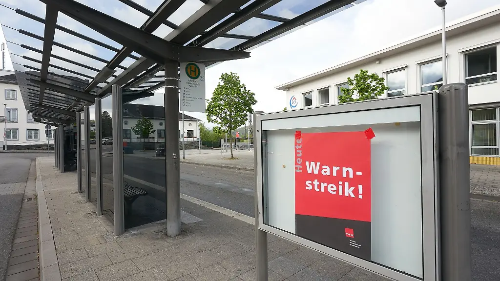 Ein-Plakat-mit-der-Aufschrift-Warnstreik-haengt-an-der-Bushaltestelle-am-Bahnhof-an-dem-die-Linienbusse-von-DB-Regio-halten
