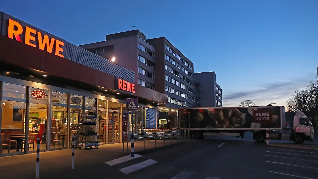 Ein-Lkw-steht-am-fruehen-Morgen-vor-einem-Rewe-Supermarkt-der-mit-Waren-beliefert-wird