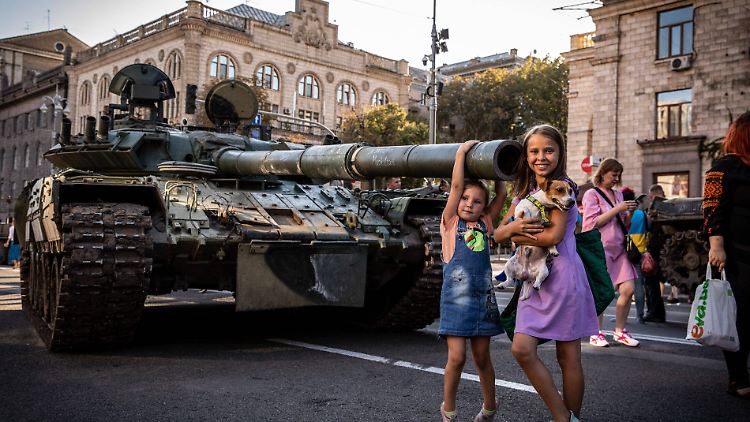 Auf ihrer Flucht haben russische Streitkräfte auch viele Panzer zurückgelassen. Ukrainische Familien machen Fotos mit den erbeuteten Waffen. 