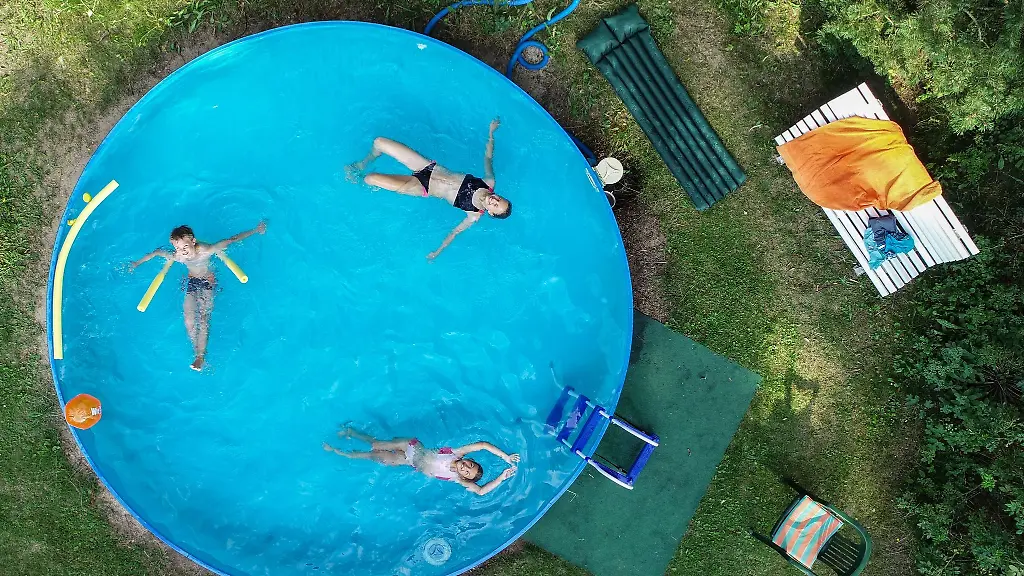 Drei-Kinder-planschen-in-einem-Gartenpool