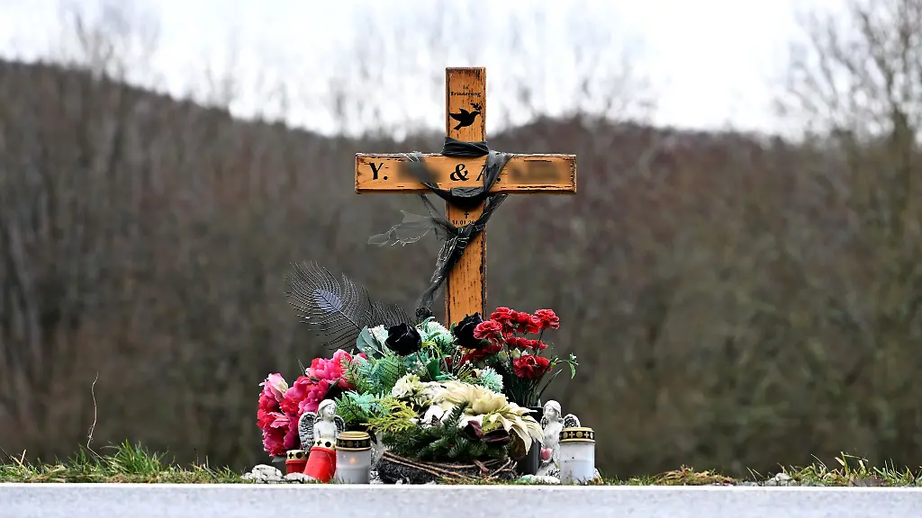 Ein-mit-Blumen-und-Schutzengeln-geschmuecktes-Holzkreuz-steht-am-Tatort-wo-am-31-Januar-2022-ein-Mann-eine-24-Jahre-alte-Polizeianwaerterin-und-einen-29-Jahre-alten-Polizist-erschossen-hat-als-sie-bei-einer-naechtlichen-Streife-einen-Wilderer-stellen