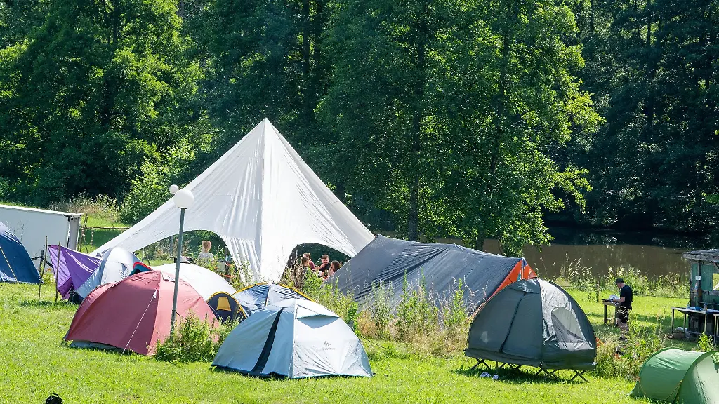 Vor-einem-Gemeinschaftszelt-stehen-Einzelzelte