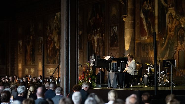 Knieprobleme lassen Merkel ihre Rede im Kaisersaal sitzend halten.