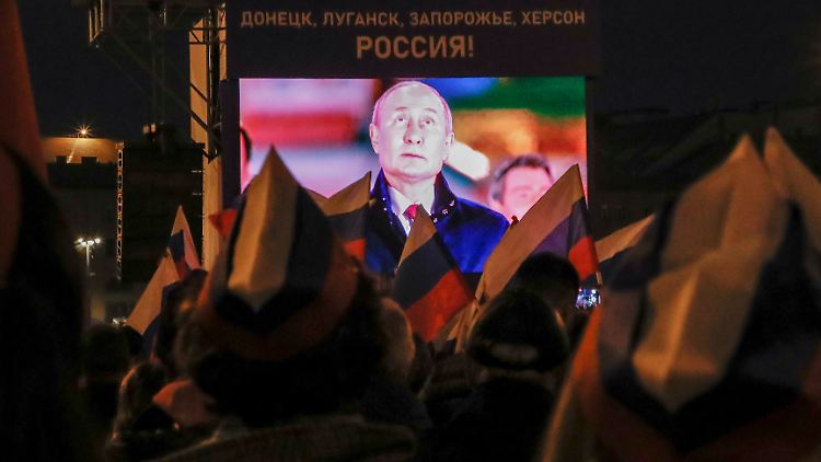Putin blickt nach oben, die Menge auf ihn. Der russische Präsident inszenierte sein völkerrechtswidriges Vorgehen auf dem Roten Platz.