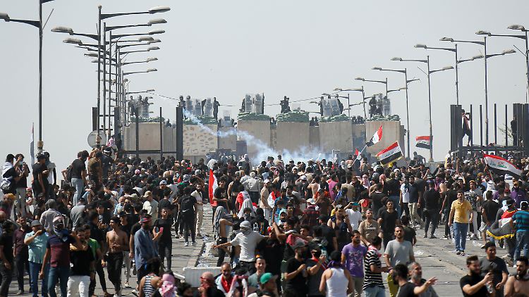 Polizisten feuern während einer Demonstration der Anti-Regierungs-Proteste auf dem Tahrir-Platz Tränengas auf Demonstranten.