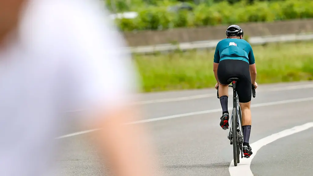 Ein-Radfahrer-faehrt-in-der-Sonne-auf-seinem-Rennrad