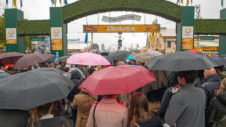Dieses Bild gehörte bei der diesjährigen Wiesn dazu: Besucherinnen und Besucher betreten mit Regenschirmen das Festgelände.