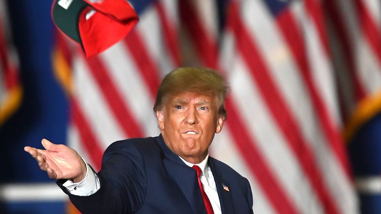Der ehemalige US-Präsident Trump wirft bei einer Kundgebung in Michigan Basecaps in die Menge seiner Zuhörer.