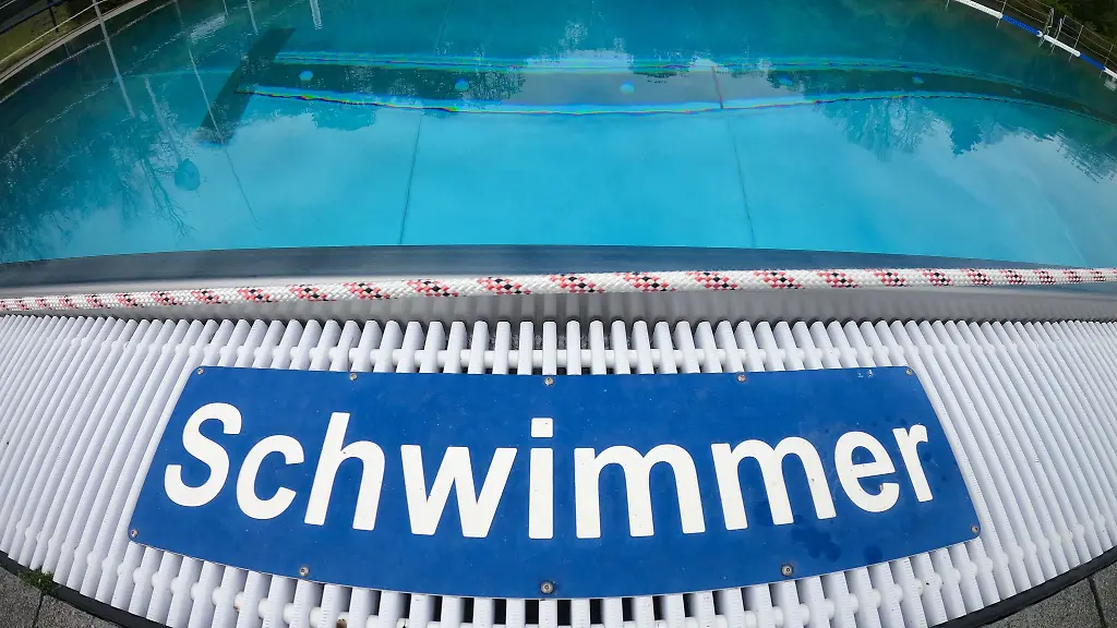 Schwimmer-steht-am-Beckenrand-in-einem-Freibad