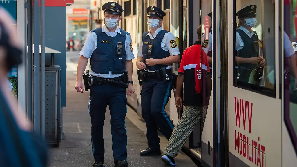 Zwei-Polizisten-steigen-an-einer-Tram-Haltestelle-aus-der-Strassenbahn-aus