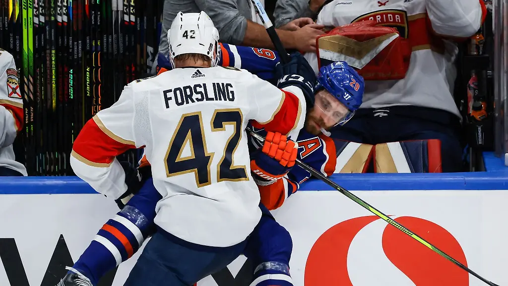 Leon-Draisaitl-von-den-Edmonton-Oilers-wird-von-Gustav-Forsling-von-den-Florida-Panthers-an-die-Bande-gecheckt