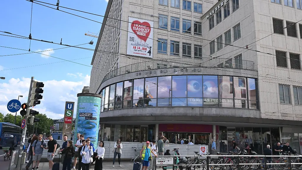 Plakate-haengen-vor-der-Eroeffnung-der-Pop-up-Ausstellung-The-House-of-Banksy-An-Unauthorized-Exhibition-an-der-ehemaligen-Galeria-Kaufhof-am-Stachus