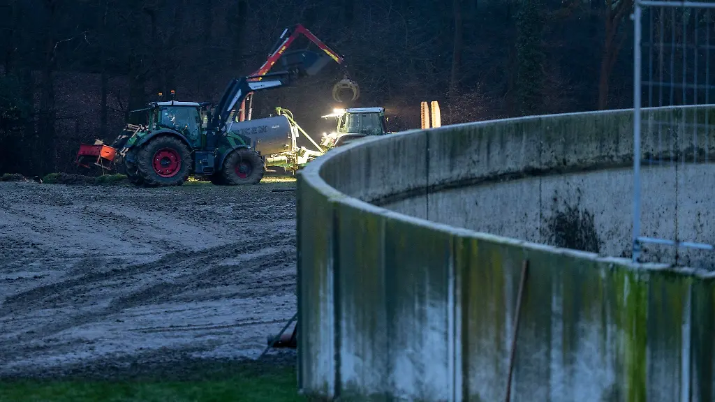 Ein-Landwirt-versucht-mit-Helfern-Guelle-von-seinem-Feld-zu-beseitigen
