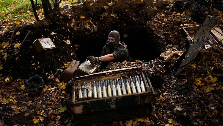 Ein Mitglied der ukrainischen Streitkräfte nimmt zurückgelassene russische Munition in der Region Cherson auf. 