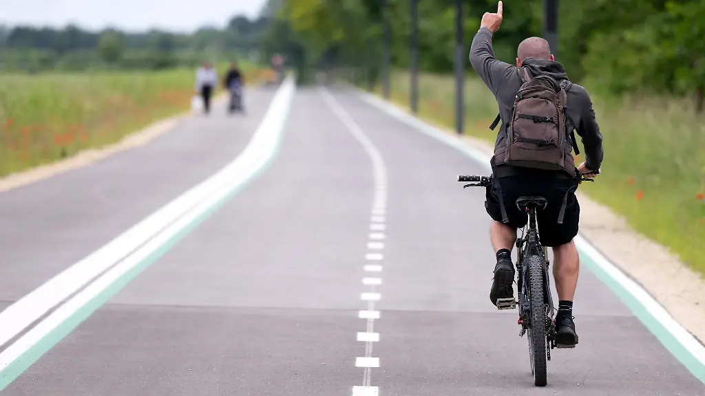 Ein-Mann-faehrt-mit-einem-Fahhrad-bei-einem-Pressetermin-ueber-die-Radschnellverbindung-zwischen-Muenchen-Garching