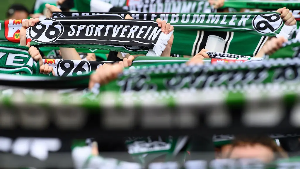 Hannovers-Fans-stehen-mit-ihren-Schals-auf-der-Tribuene