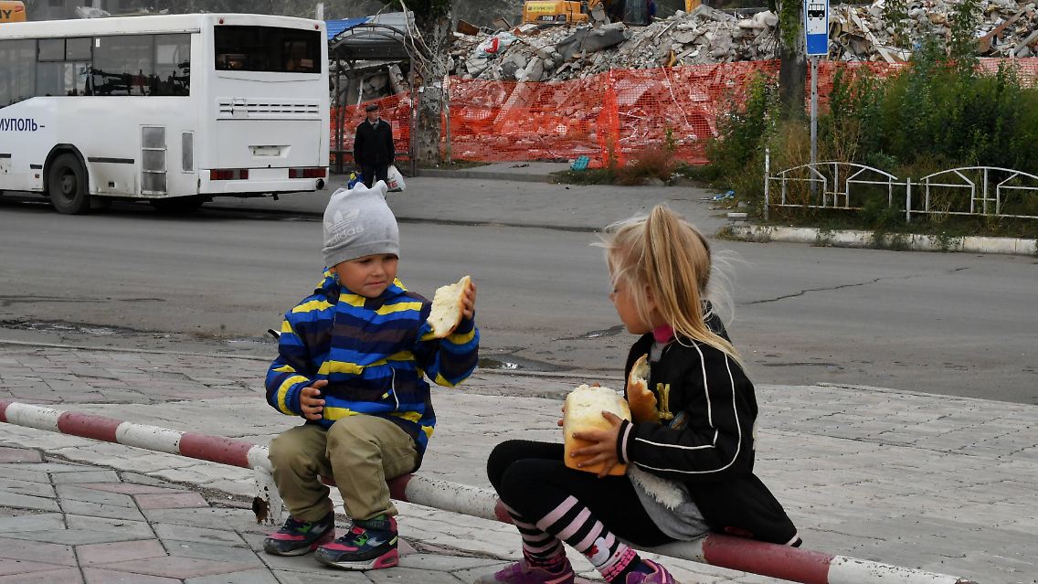 Ukrainische Kinder spielen im von Russland besetzten Mariupol auf der Straße.