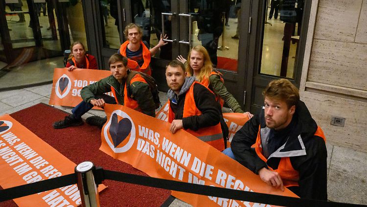 Aktivisten der radikalen Klimagruppe "Letzte Generation" blockieren gemeinsam mit Scientist Rebellion den Eingang zum Weltgesundheitsgipfel in Berlin am 16. Oktober.