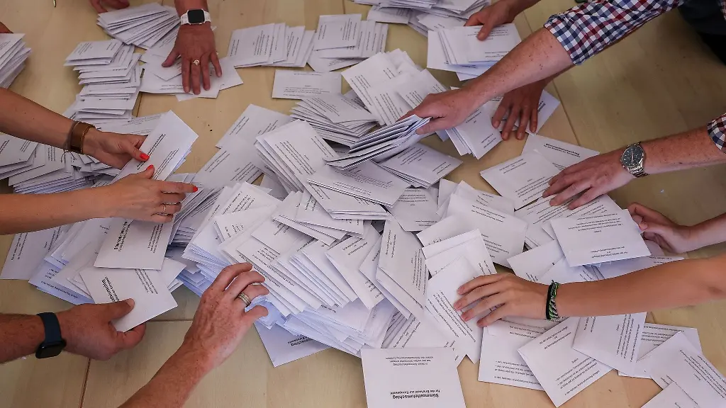Zahlreiche-Wahlhelfer-nehmen-sich-bei-der-Stimmenauszaehlung-die-Umschlaege-mit-den-Briefwahlstimmen-zur-Europawahl