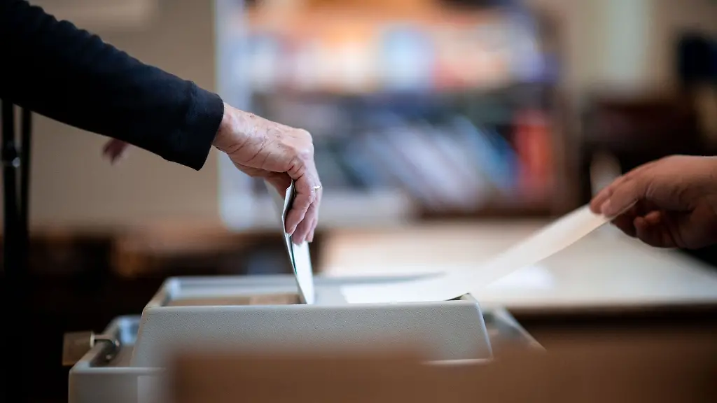 Eine-Frau-wirft-ihren-Stimmzettel-in-ein-Wahlurne-in-einem-Wahllokal-in-Essen