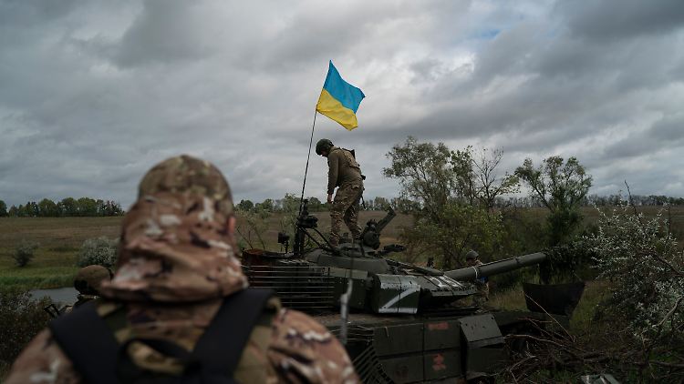 Ein ukrainischer Soldat auf einem zerstörten russischen Panzer in der Region Charkiw.