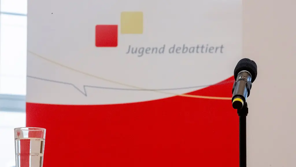 Ein-Mikrofon-und-ein-Glas-Wasser-stehen-vor-der-Veranstaltung-Jugend-debattiert-mit-Spitzenkandidaten-auf-einem-Rednerpult