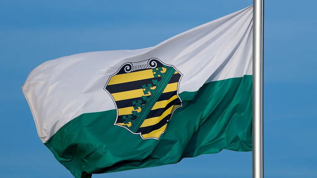 Die-Flagge-vom-Bundesland-Sachsen-mit-dem-saechsischen-Wappen-weht-im-Wind