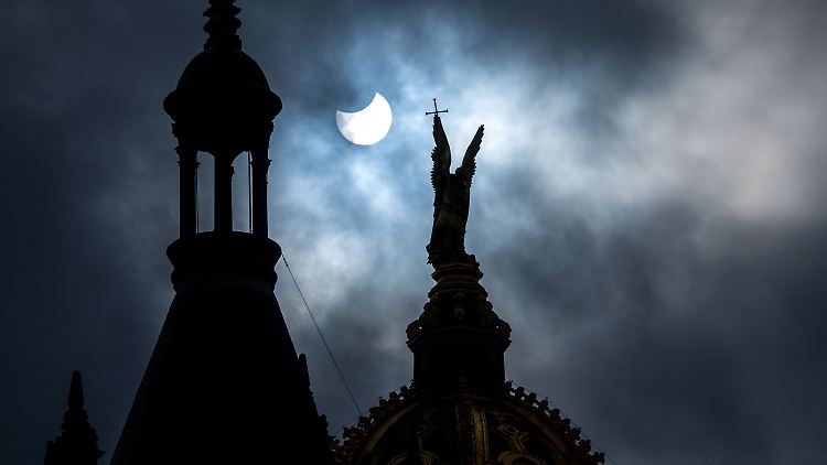 Die partielle Sonnenfinsternis über der vergoldeten Statue des Erzengel Michael auf der Kuppel des Schweriner Schlosses.