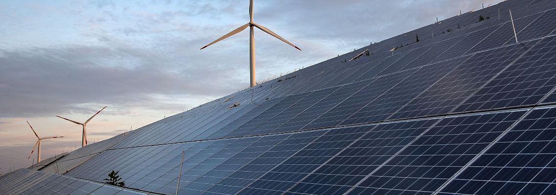 Windkraftanlagen stehen hinter Photovoltaikanlagen.