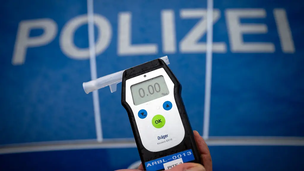 Ein-Polizeibeamter-haelt-waehrend-einer-Verkehrskontrolle-ein-Messgeraet-Alcotest