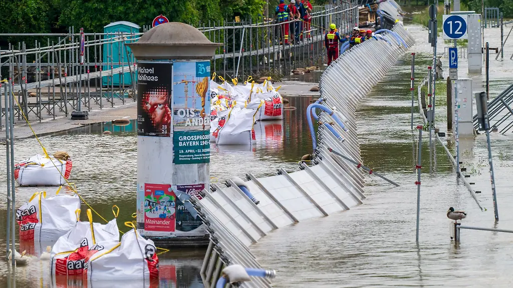 Mitarbeitende-der-Wasserwacht-kontrollieren-die-provisorischen-Schutzwaende-an-der-Donau-in-der-Altstadt
