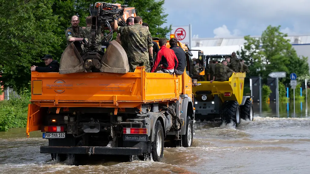 Soldaten-fahren-mit-einem-Lastwagen-ueber-eine-ueberflutete-Strasse-im-Ortskern