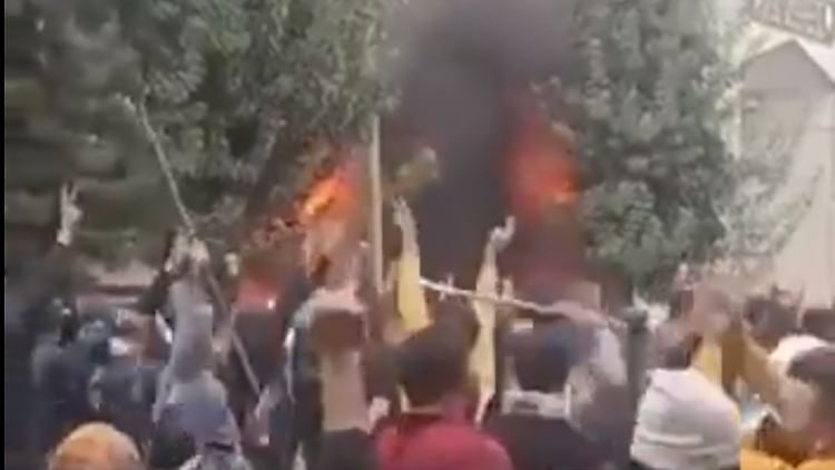 Die nicht verifizierbaren Bilder sollen Demonstranten in Mahabad vor einem brennenden Gebäude zeigen.